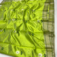 Close-up of white floral buttas and dark green leaves on a luminous parrot green Chanderi silk saree.