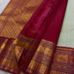 Close-up of maroon zari woven pallu and border with sage green body and gold paisley buttas