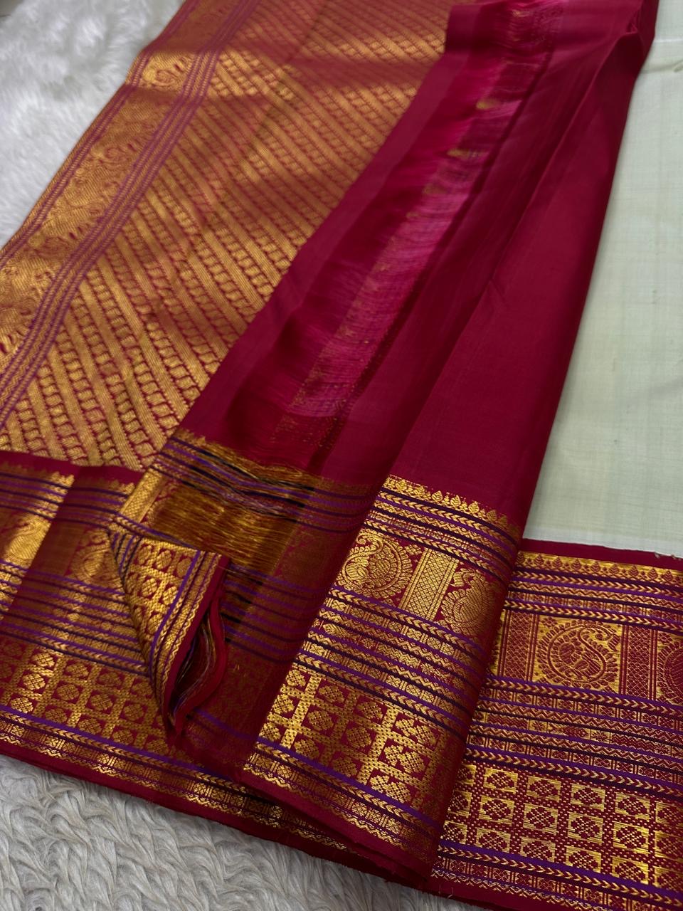 Close-up of maroon zari woven pallu and border with sage green body and gold paisley buttas