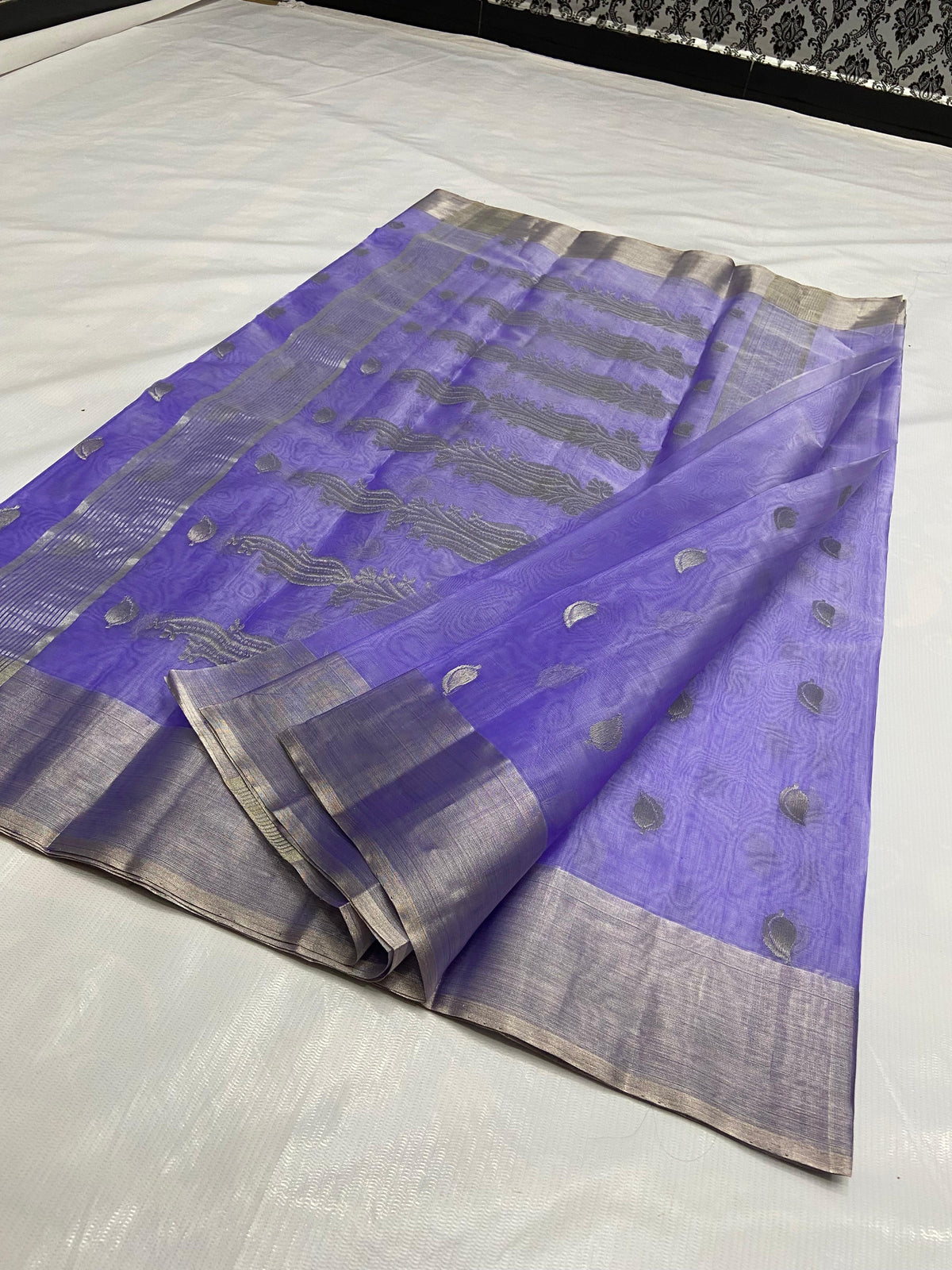 Amethyst lavender Chanderi Pattu silk saree laid open showing the ornate silver-toned paisley-vine pallu