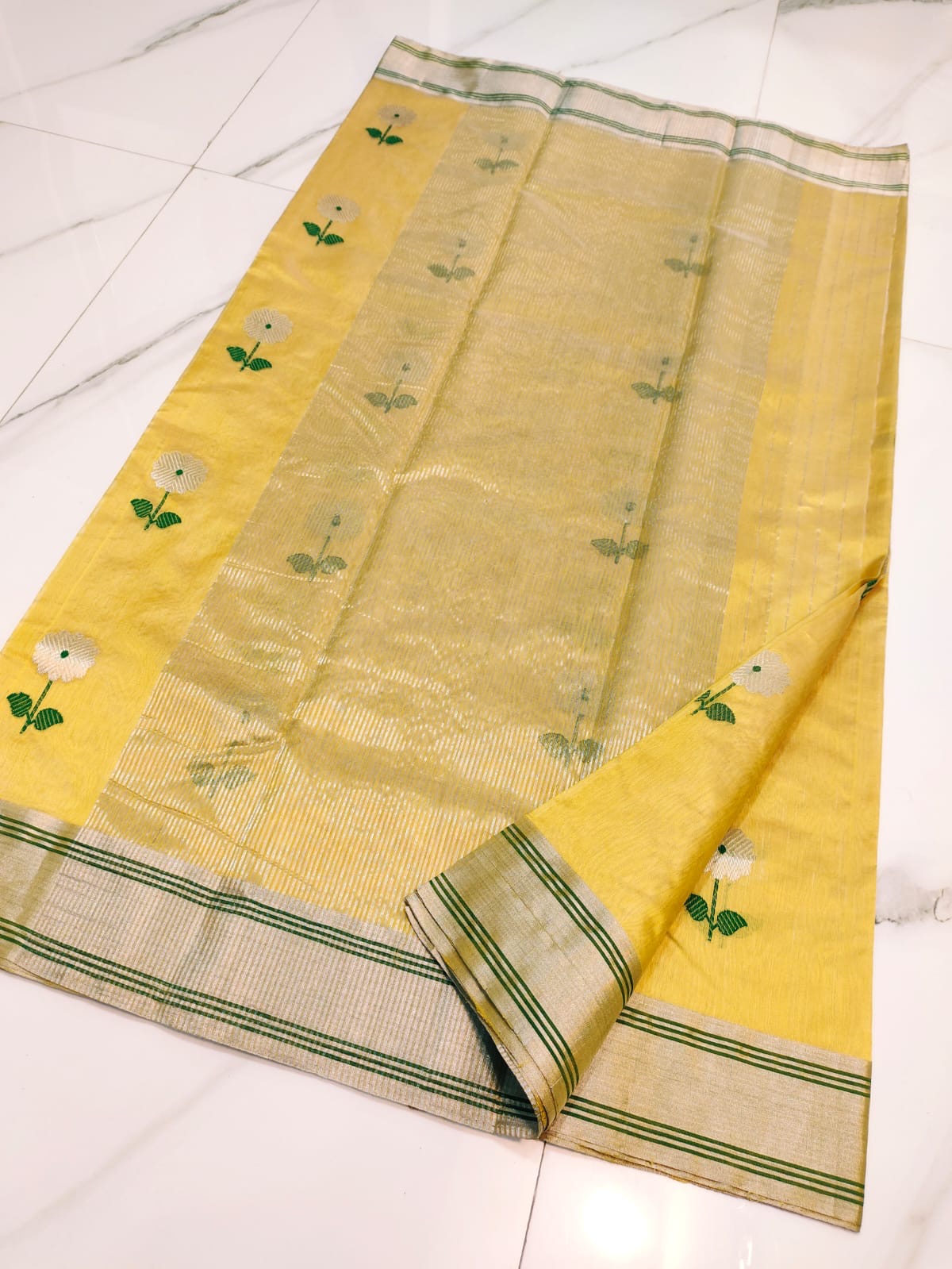 Turmeric Yellow Pattu Silk Chanderi saree body detail with silver circular floral motifs and green stems