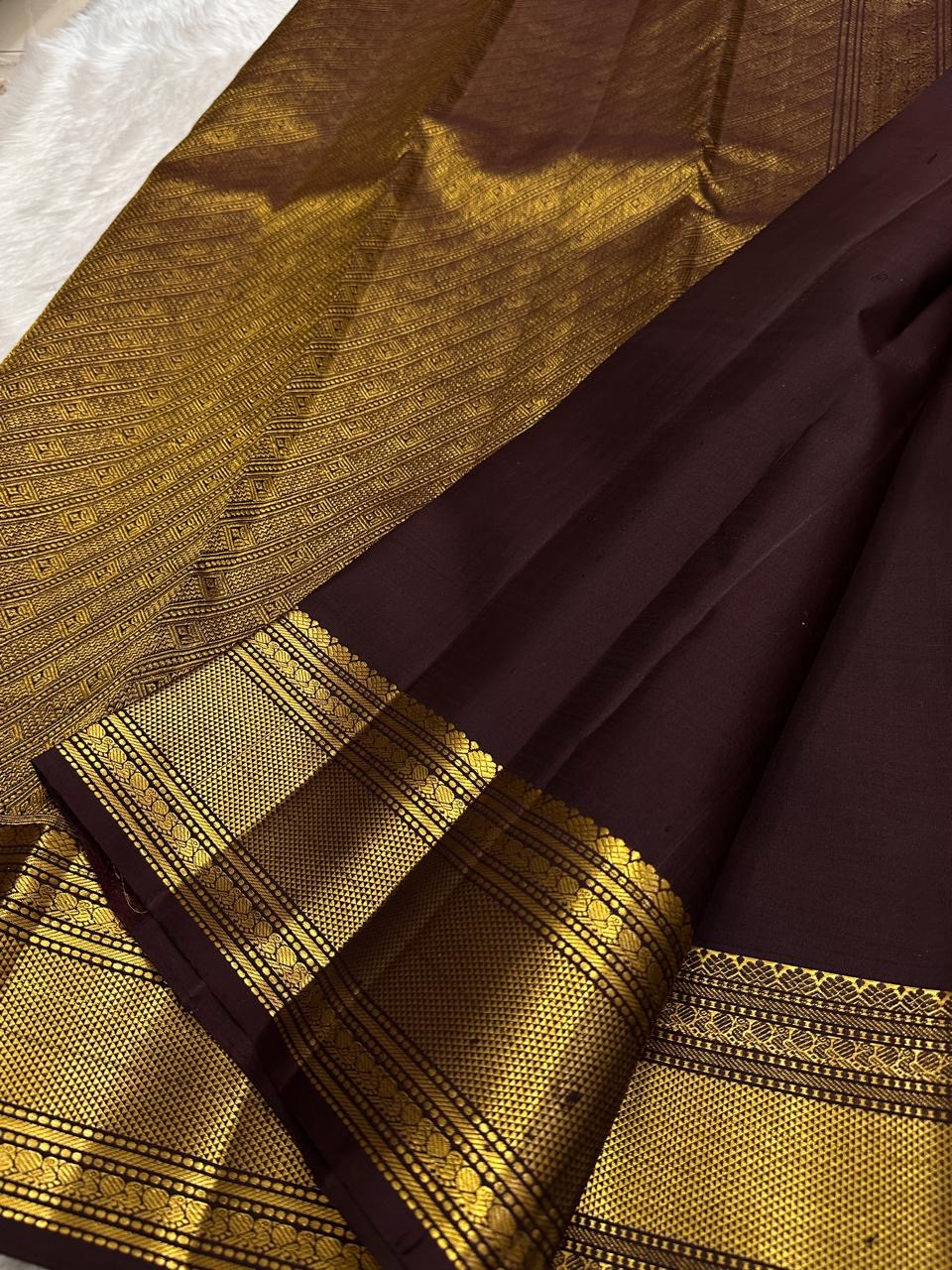 Close detail of small Pavun zari buttas aligned across deep brown handwoven Kanjivaram silk