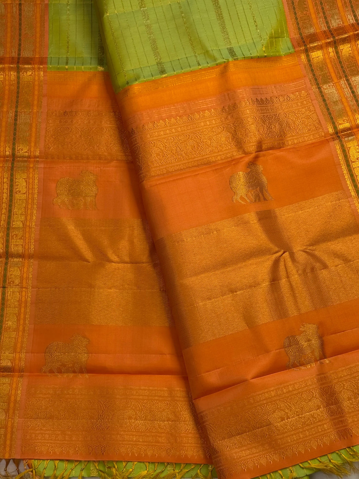 Peach-gold Vanasringaram border with layered Vanki Pet zari work on an ilampachai green Kanchipuram saree.