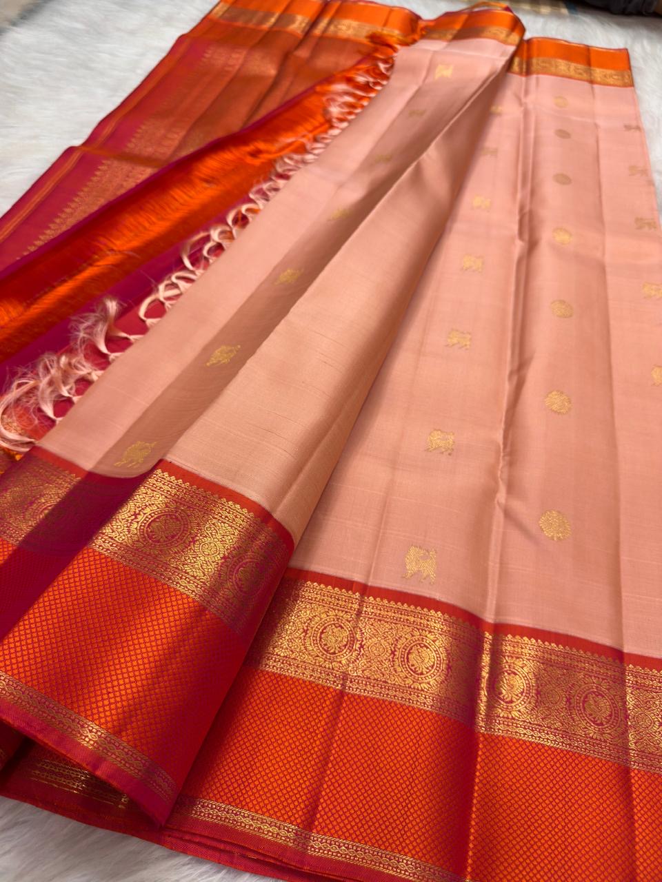 Soft peach pink Kanjipuram saree, paisley zari border close-up