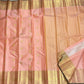 Handwoven peach-pink Pure Silk Kanchipuram saree with spaced gold buttas and a luminous broad zari border.