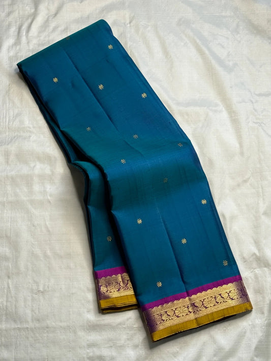 Close-up of Kamalam Butta gold-zari motifs on peacock blue Kancheepuram silk body