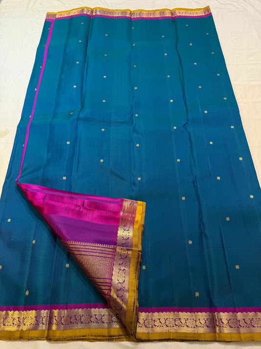 Peacock blue Butta Kancheepuram silk saree folded, showing full drape and border