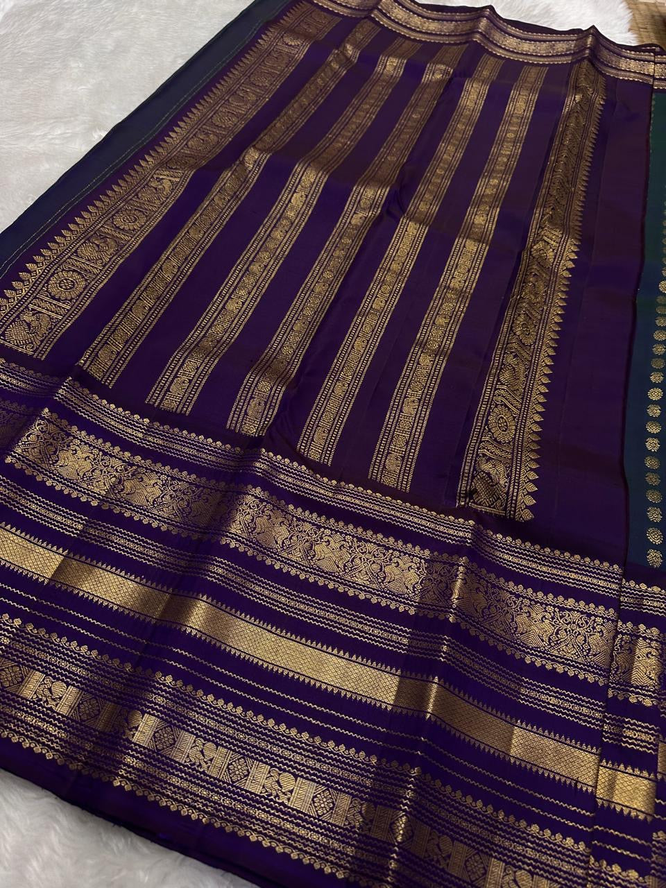 Peacock blue Kanjivaram silk body close-up showing petite mayil chakram butta motifs