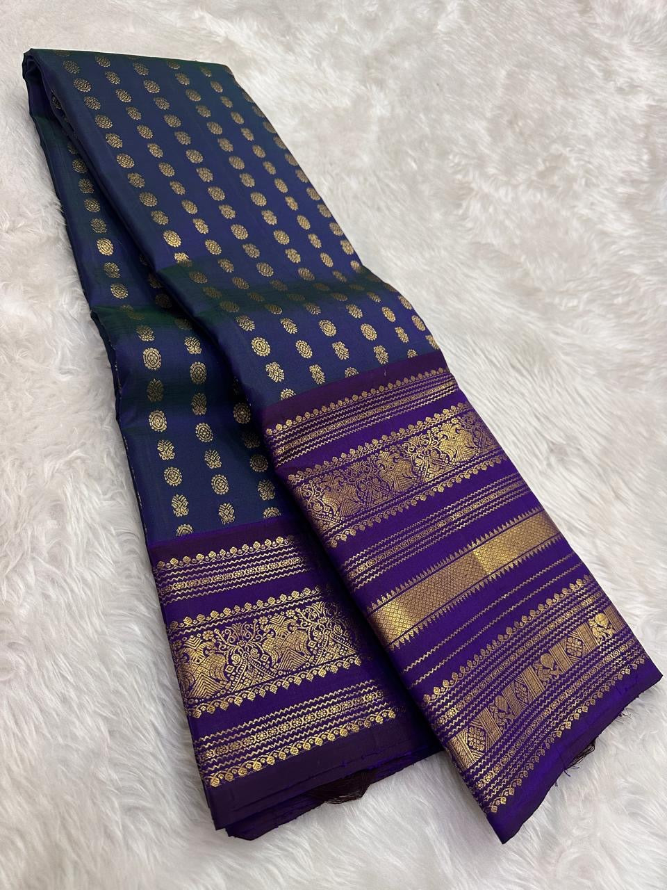 Grand pallu with dense gold zari bands on peacock blue Kanjivaram silk saree