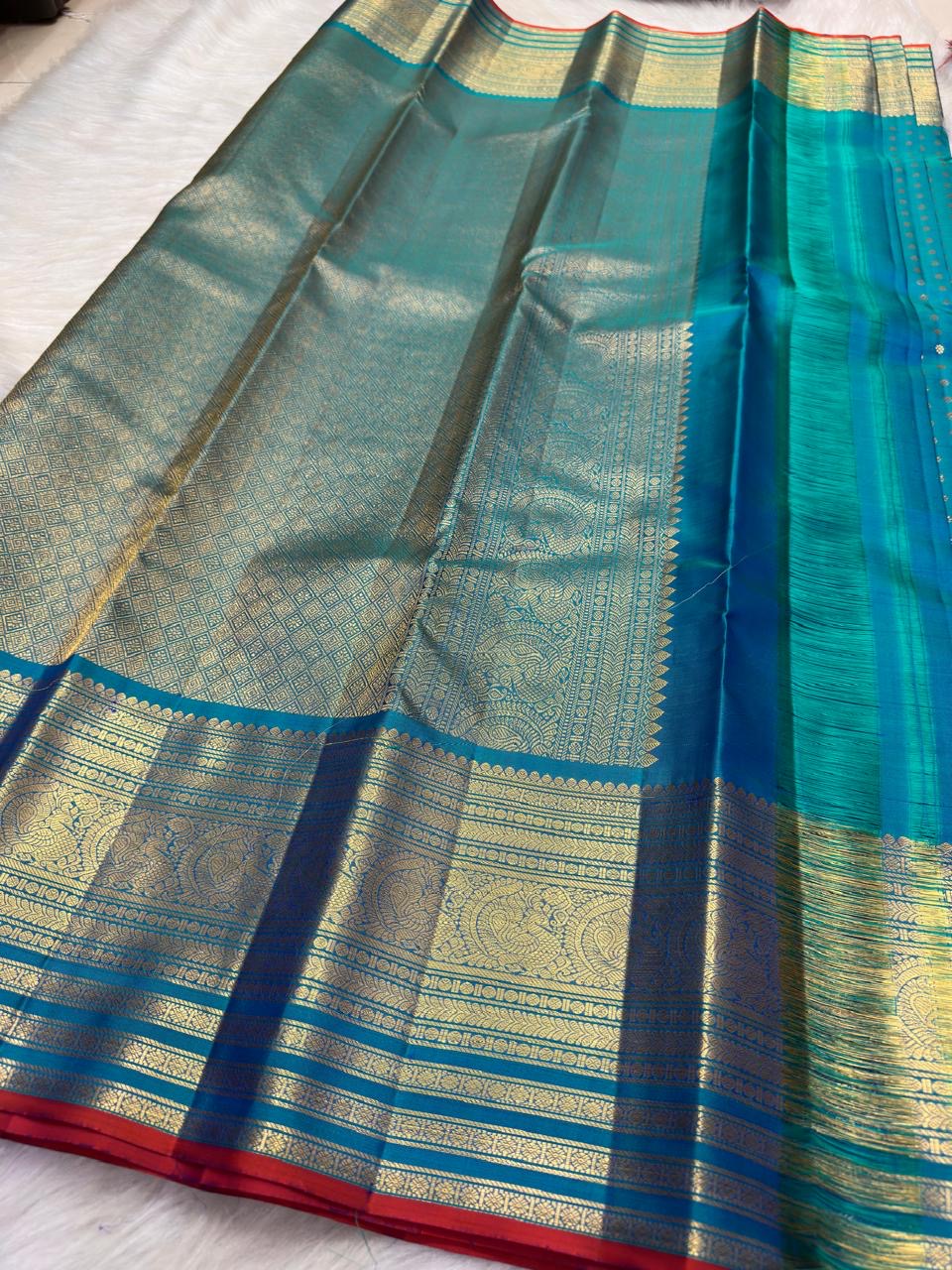 Close view of antique-gold zari border on radiant Sapphire Blue Kanchipuram silk.