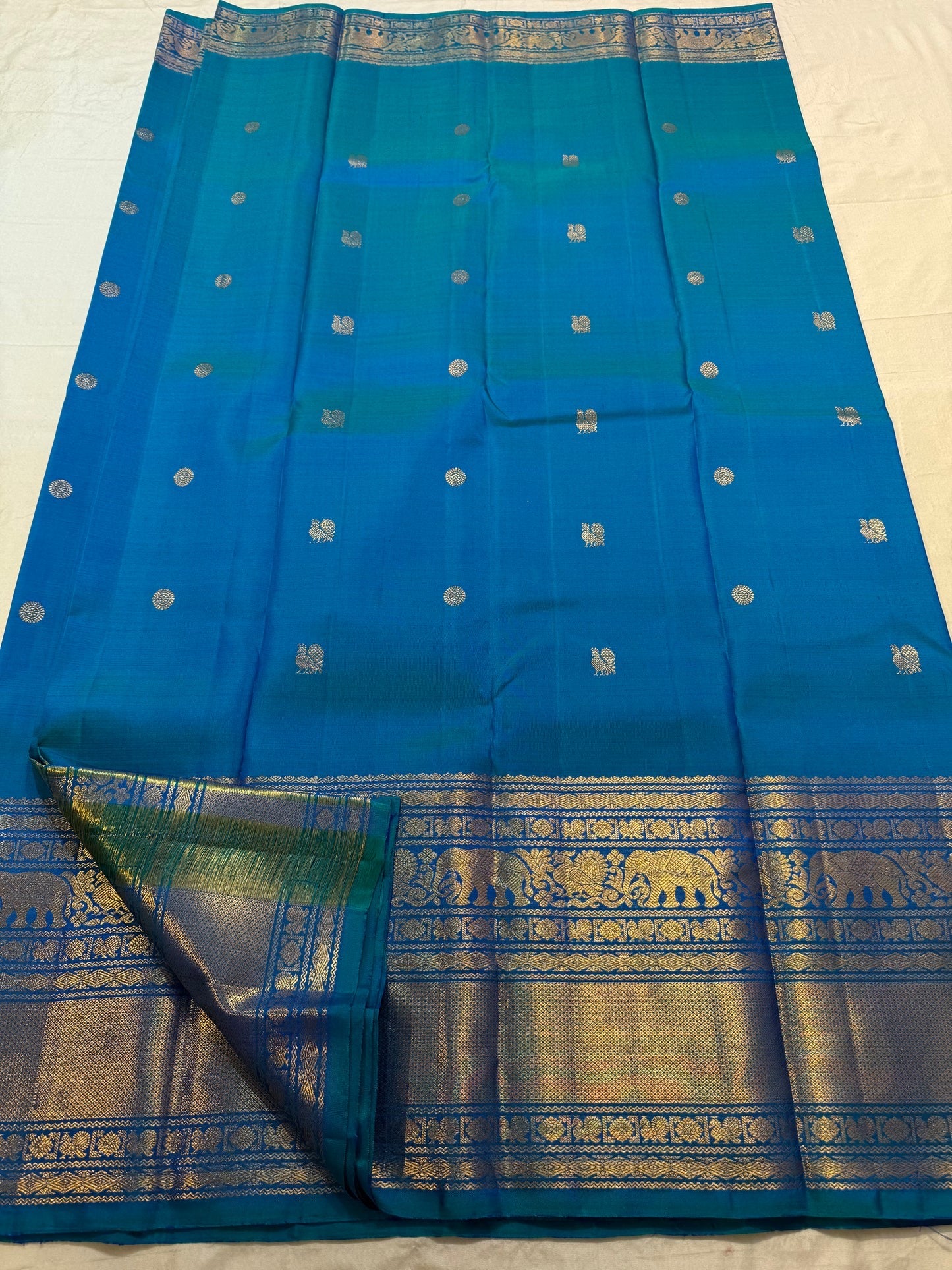Peacock Blue silk saree with spaced gold zari buttas.
