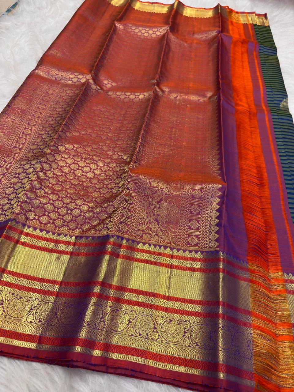 Gold zari floral and Banarasi-inspired decorative motifs across the traditional Kanchipuram contrast border.