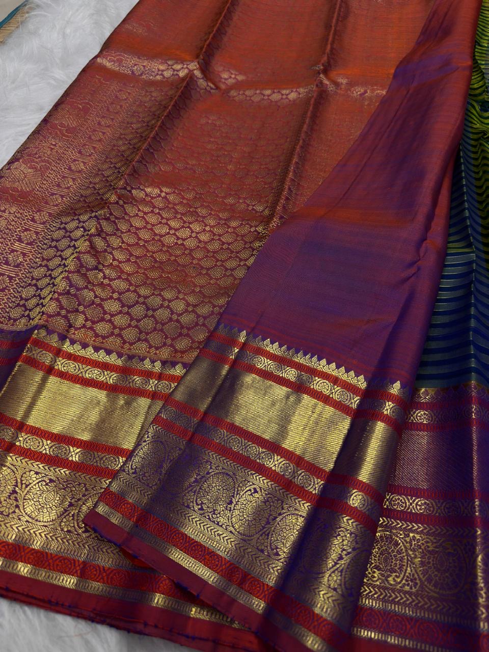 Handwoven Chen buttas spaced across the striped silk body of the peacock blue green Vairaoosi saree.