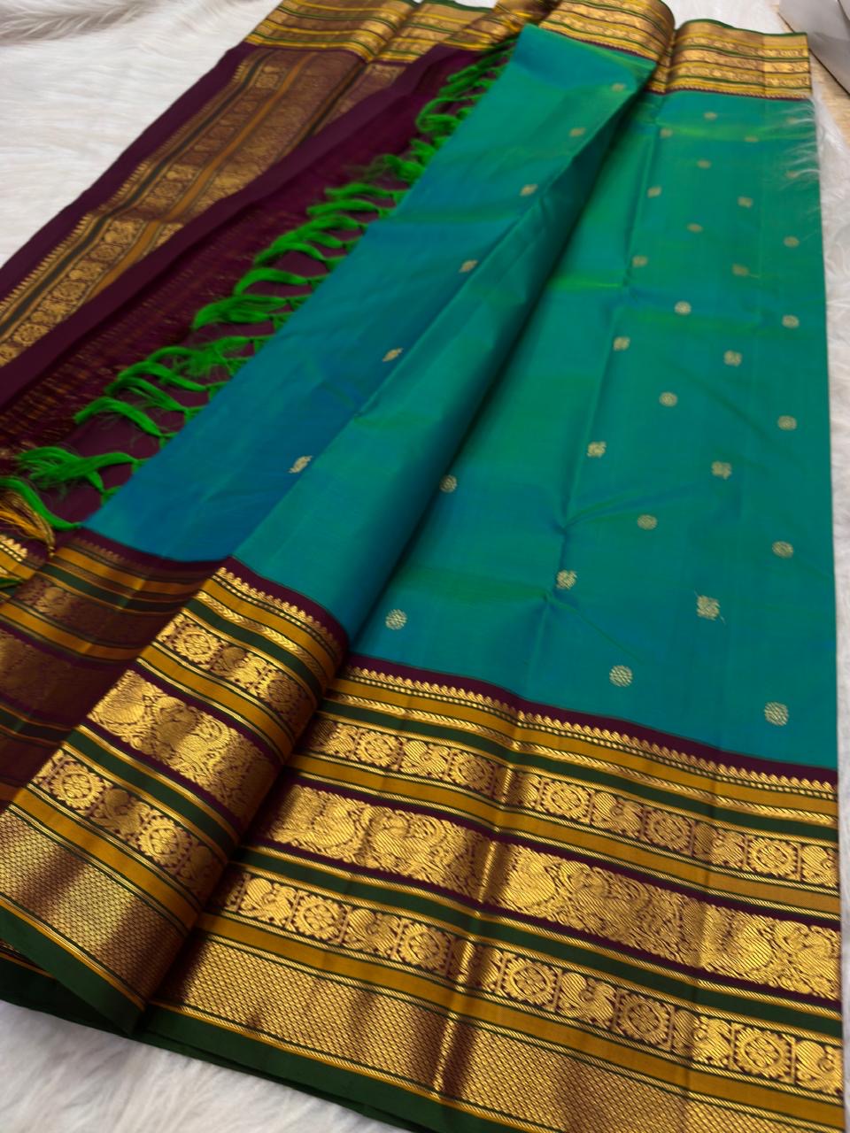 Peacock Blue-Green shot-colour Kanchipuram silk with petite zari buttas and elaborate multi-register border.