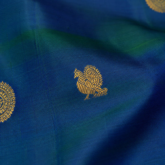 Jewel-toned peacock blue Kanchipuram silk saree with intricate Mayil Chakram buttas and traditional zari border detailing