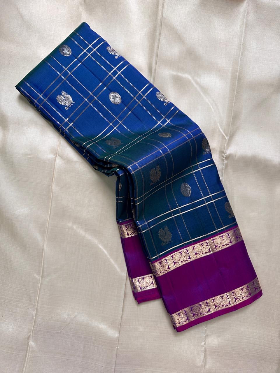Handwoven Pure Silk Kancheepuram saree in jewel-toned peacock blue and Kathiripoo purple.