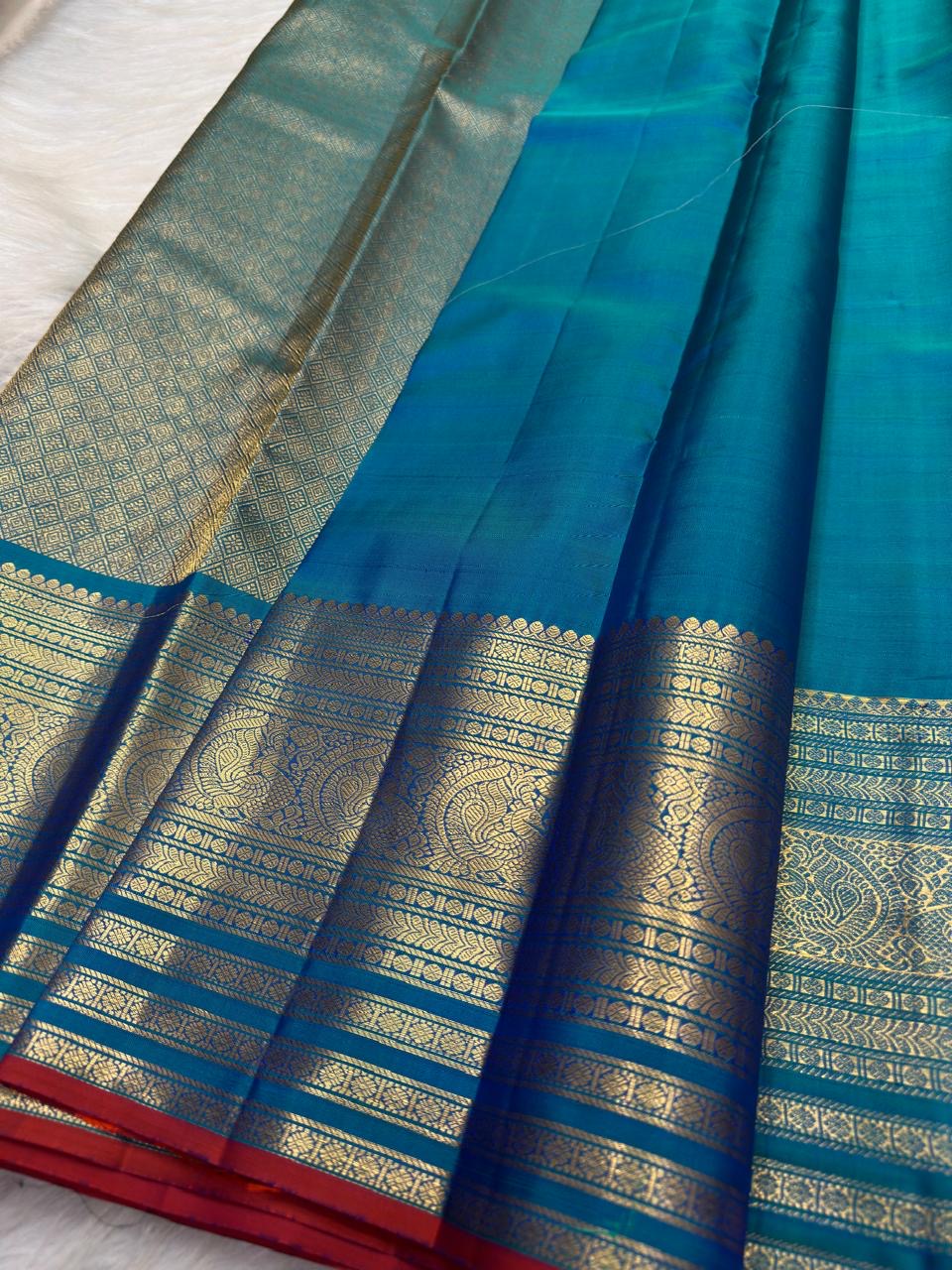 Handwoven pure silk Sapphire Blue saree with repeated small zari buttas and broad gold border.