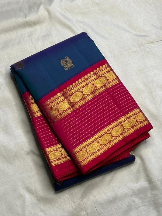 Peacock Blue Kanchipuram silk saree with alternating Mayil and Chakram gold zari buttas.