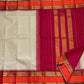 Deep pink-magenta seer pallu with gold zari stacks on a biscuit beige Kai Korvai Kanchipuram saree — Idam Living