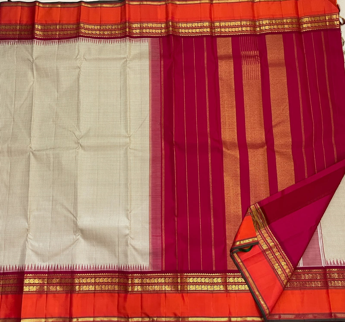 Deep pink-magenta seer pallu with gold zari stacks on a biscuit beige Kai Korvai Kanchipuram saree — Idam Living