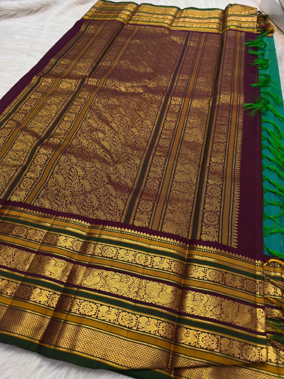 Close view of Varisaipet border with maroon, forest-green and multiple handwoven gold zari motif stripes.