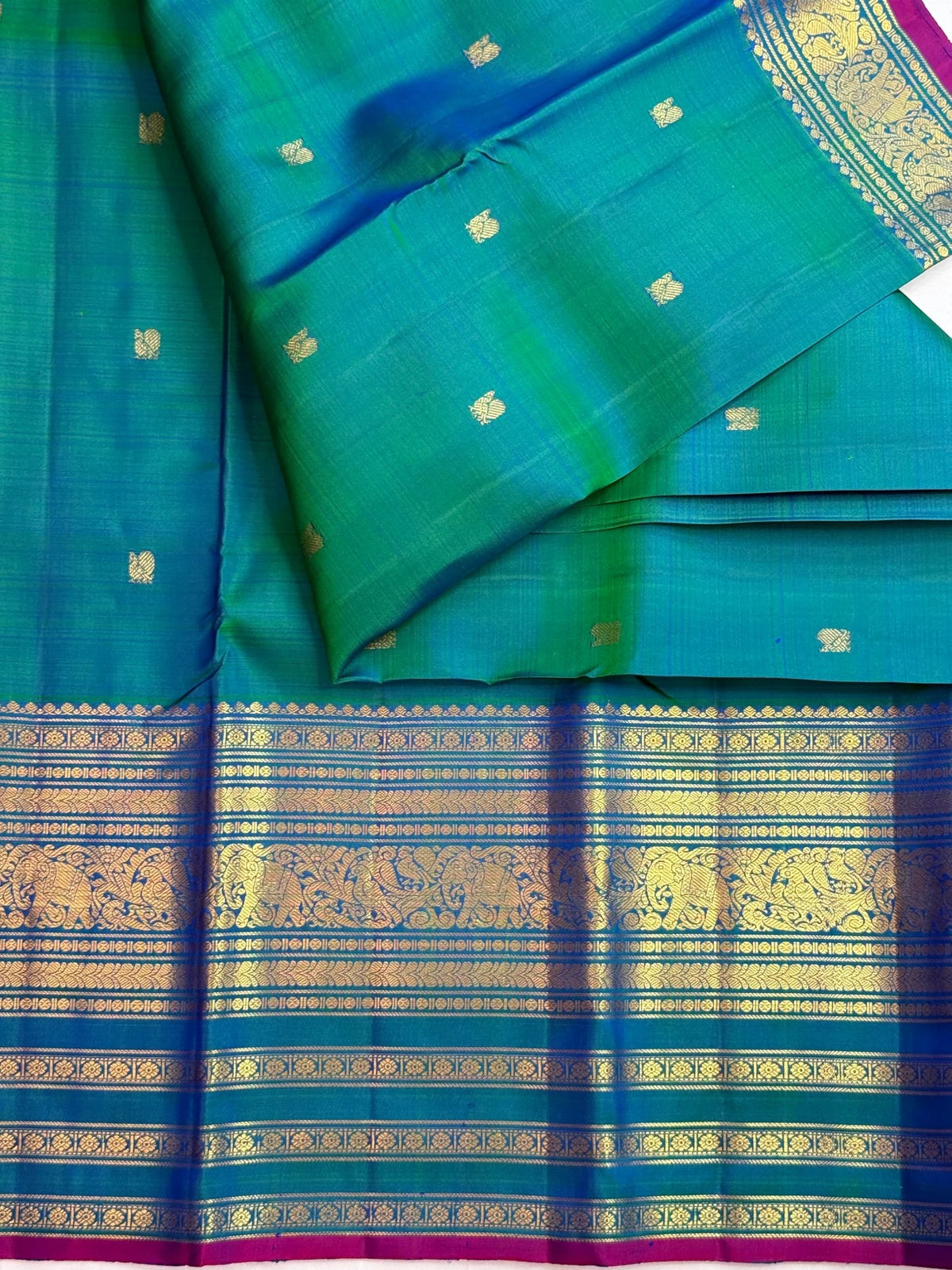 Iridescent peacock-neck blue and green pure silk Kanchipuram saree, gold varisaipet border yaanai birds; traditional Varisaipet weave.