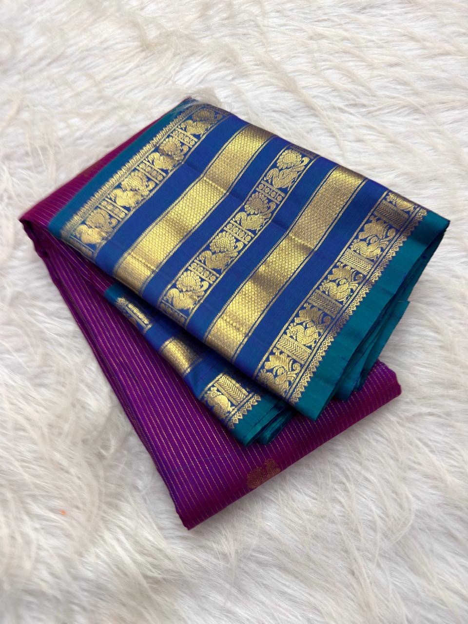 Blue-teal pallu with golden diamond lattice and floral zari panel on a Vadamalli magenta Kanchipuram saree