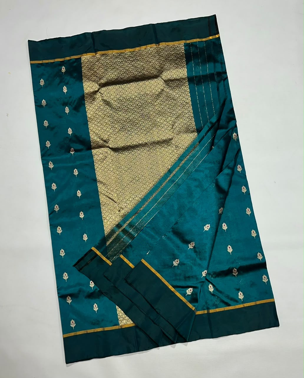 Expansive gold patterned pallu on a peacock teal Pattu Silk Chanderi saree.