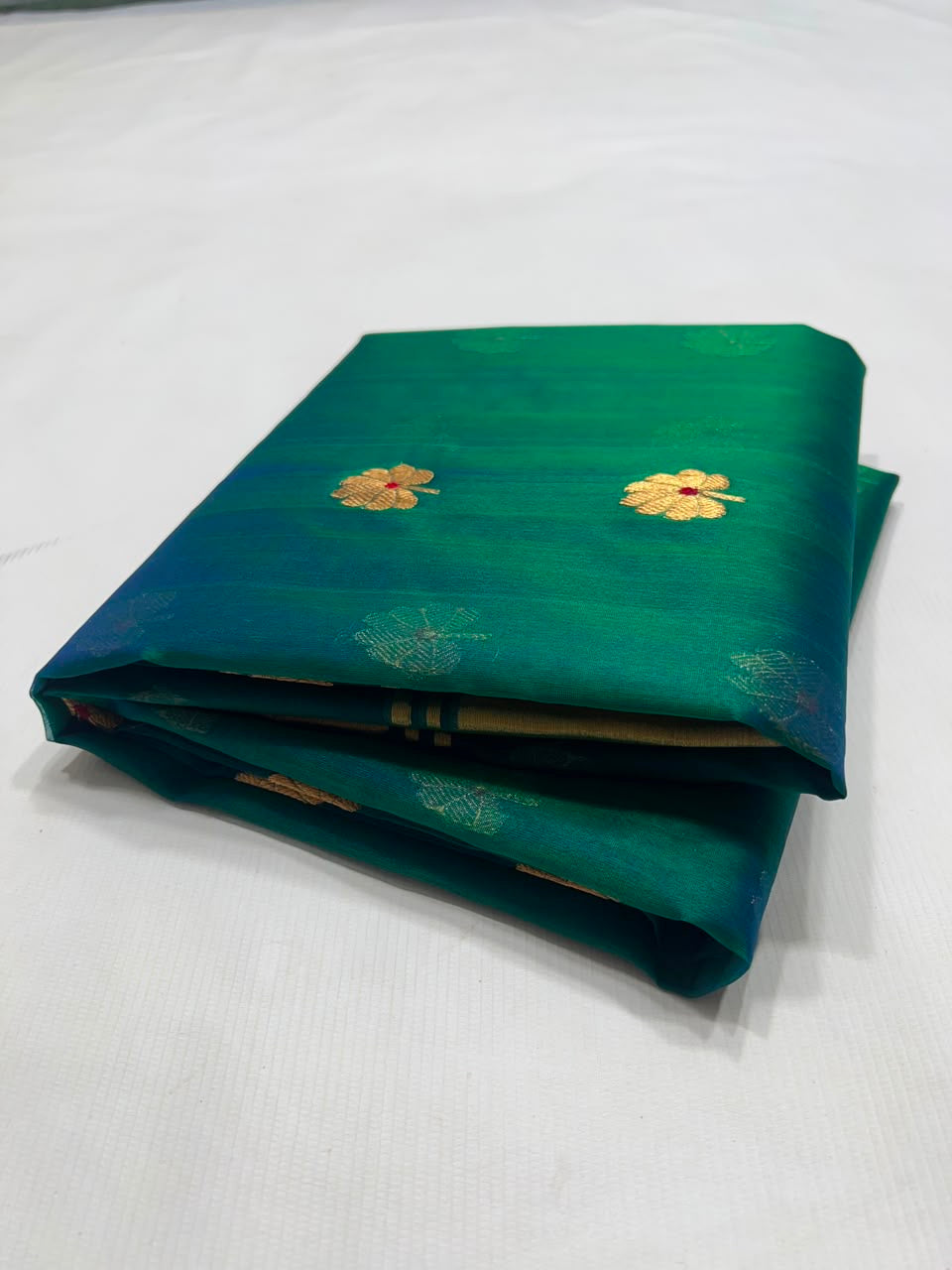 Broad gold border with fine blue-green stripes on peacock teal Chanderi saree