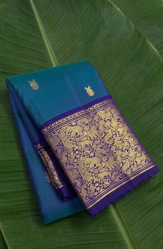 Peacock teal Kanchipuram silk saree with royal violet korvai border and Gandaberunda butta