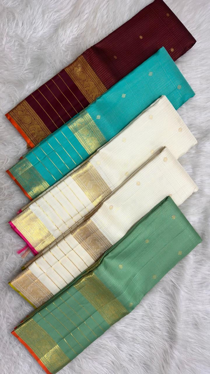 Handwoven surface detail of soft sage-leaf green silk, with shimmering gold checks and tiny lotus buttas.
