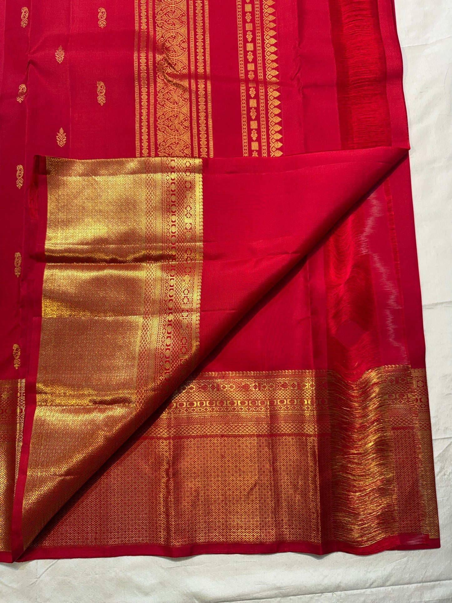 Full Pillar-Box Red Butta saree showing spaced gold motifs and broad gold zari borders.