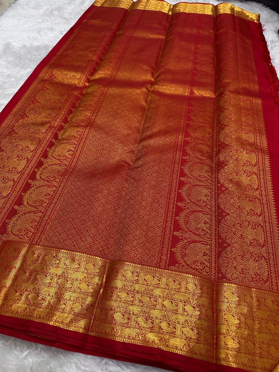 Close body view showing small spaced gold zari buttas across Pillar-Box Red silk