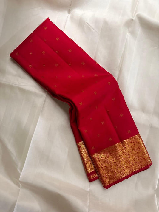 Border detail showing multiple gold zari bands with ornate handwoven motifs on Pillar-Box Red silk