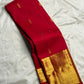 Folded Pillar-Box Red saree with compact gold buttas and broad geometric zari border.