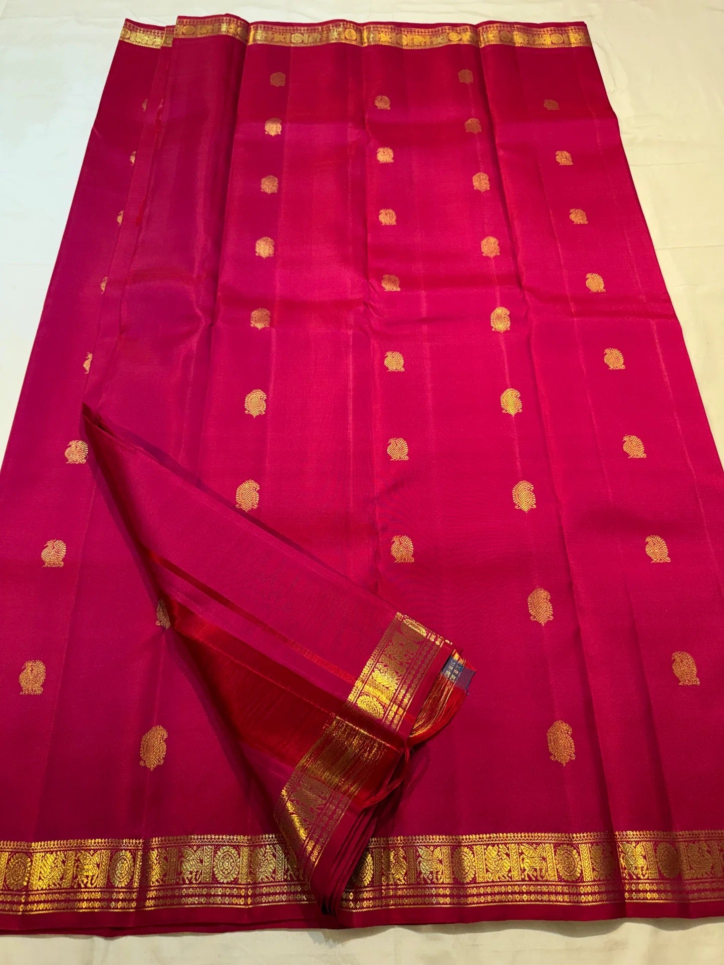 Handwoven Raspberry Pink Butta saree with traditional antique-gold zari border.