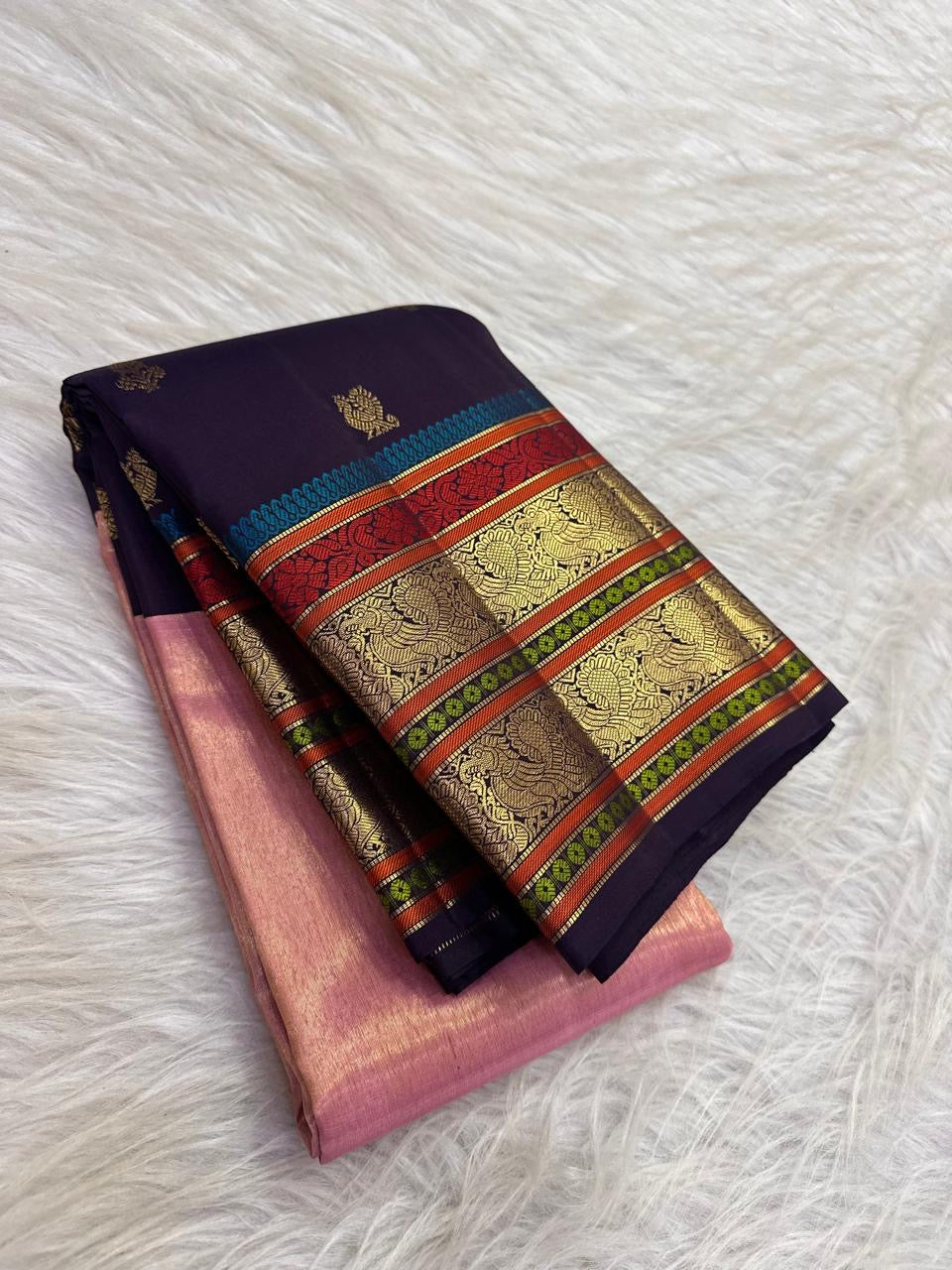 Deep aubergine frame around luminous rose pink tissue saree body