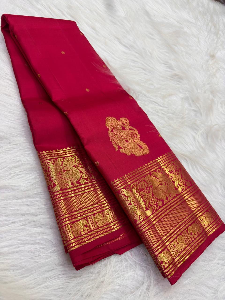 Close view of antique-gold zari buttas on Sindoor Red Kanjivaram silk.