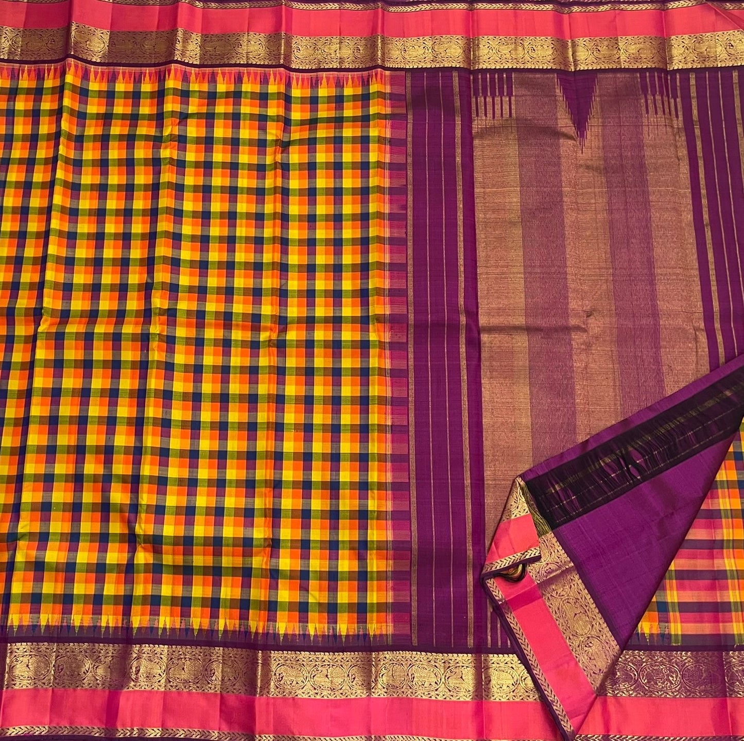 Corner fold of pure Kanchipuram silk saree highlighting gold zari border and purple silk pallu, available in the USA