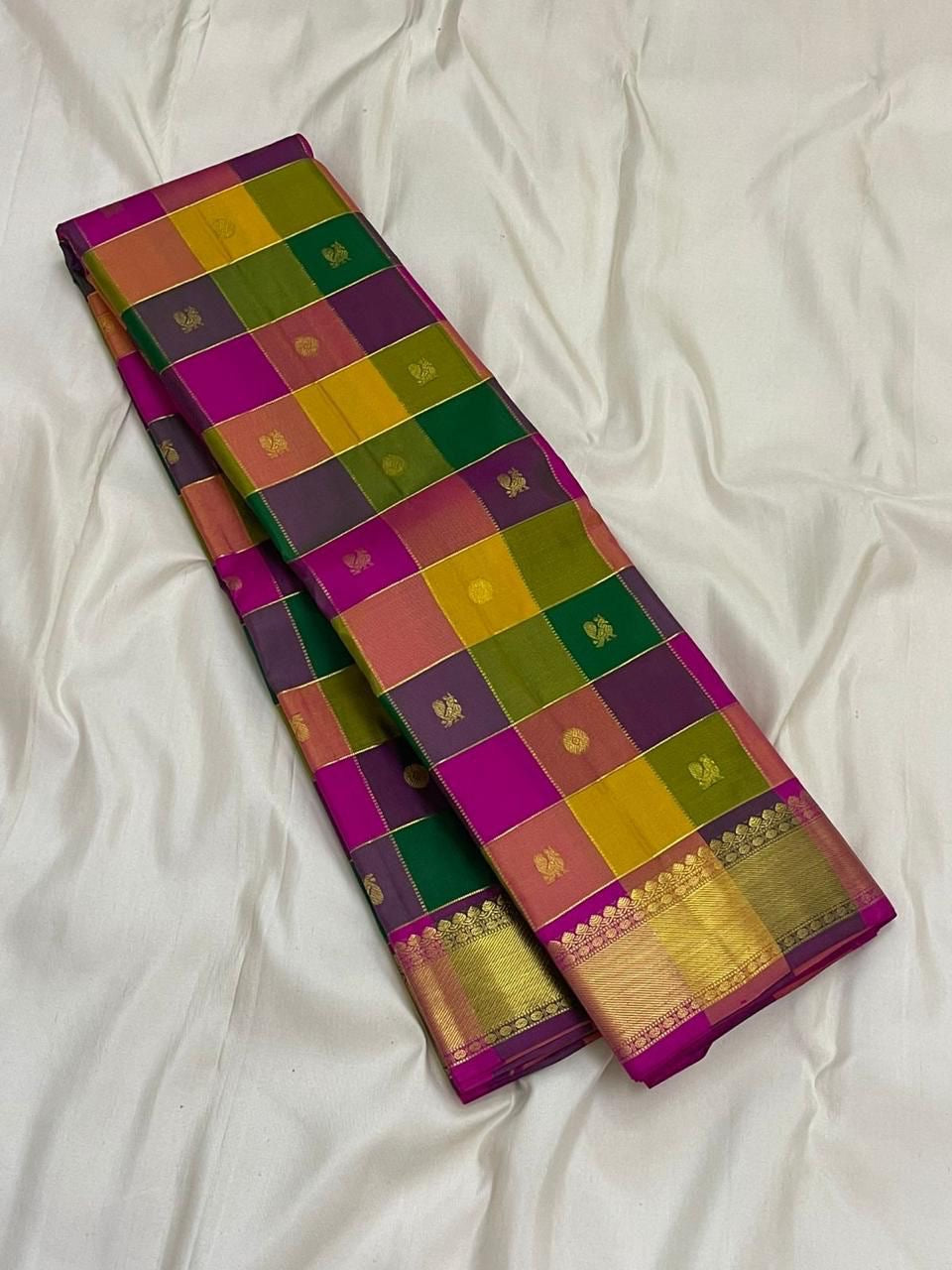 Long-folded Pure Kanchipuram silk saree showing multicolor checked body and zari woven gold border on white fabric.