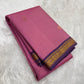 Folded rose pink Pure Kanchipuram Silk Saree with gold buttas and purple zari border on white fur background