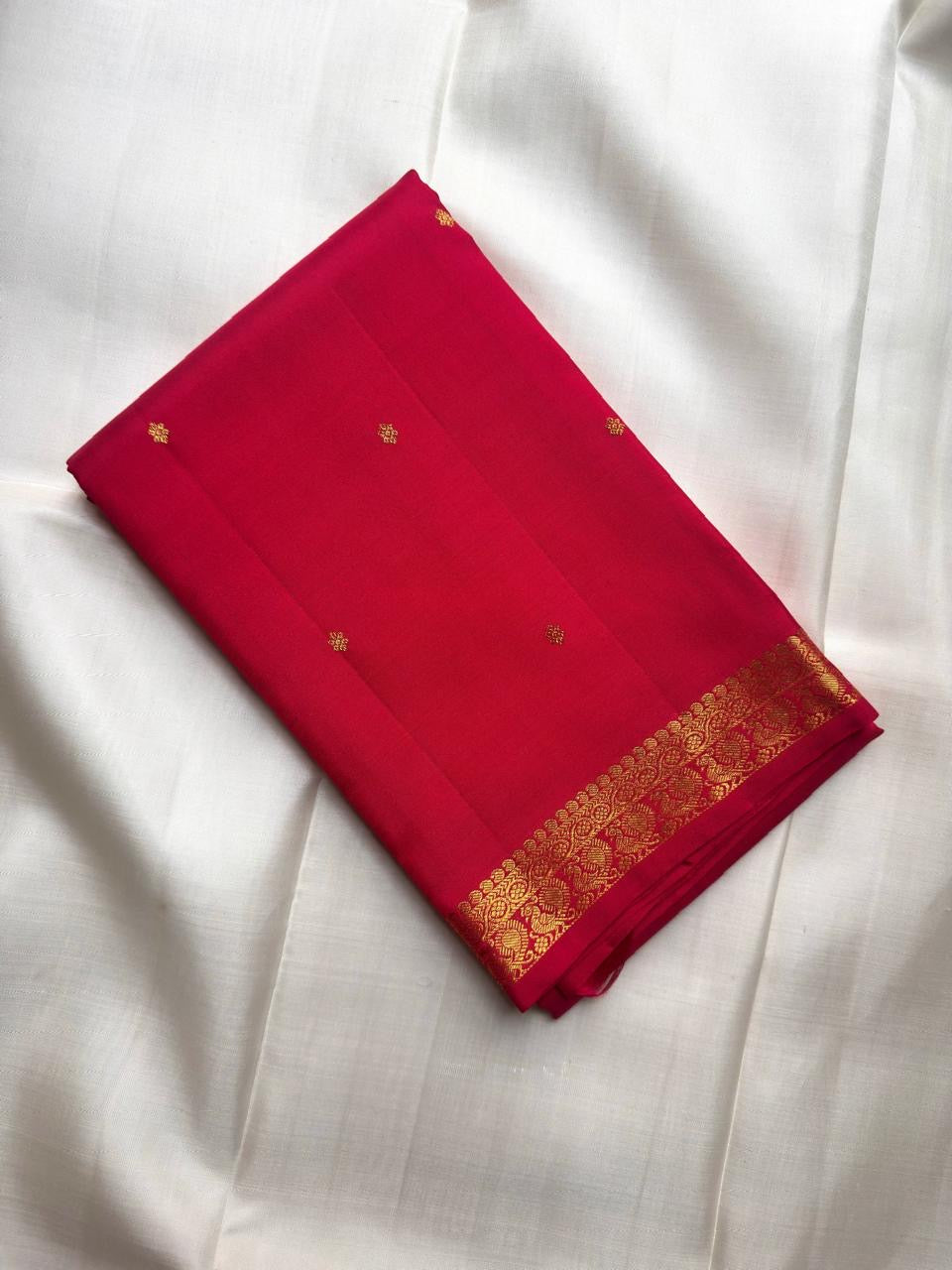 Close view of Sindoor Red pure silk meeting a broad traditional classic-gold zari border.