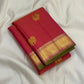 Folded rani pink vairaoosi Kanchipuram silk saree with wide gold zari border and green edge on white backdrop