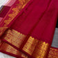 Close-up of deep red pallu section with gold zari woven border and fine silk texture