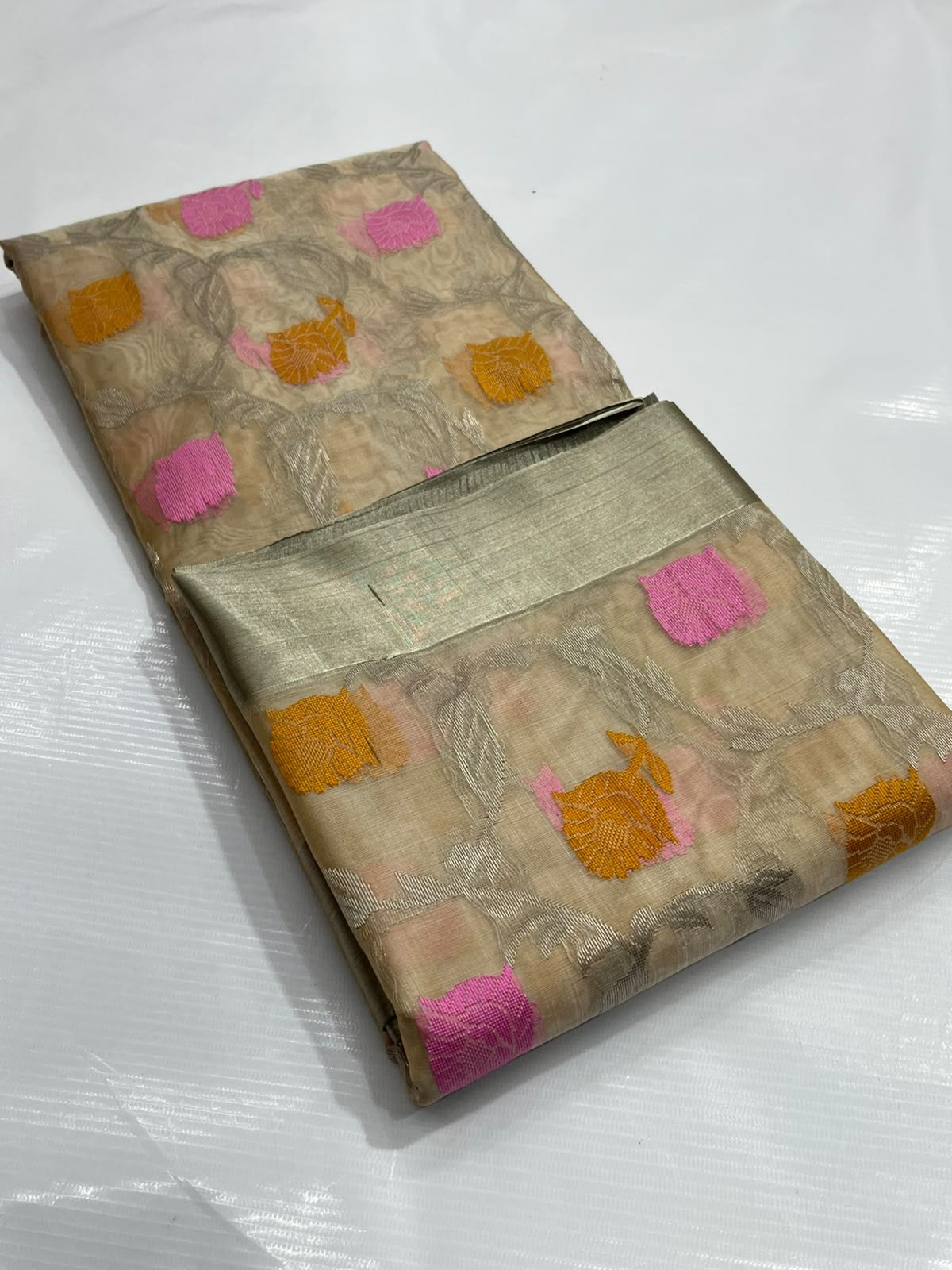 Pink and yellow woven floral accents on beige Chanderi silk