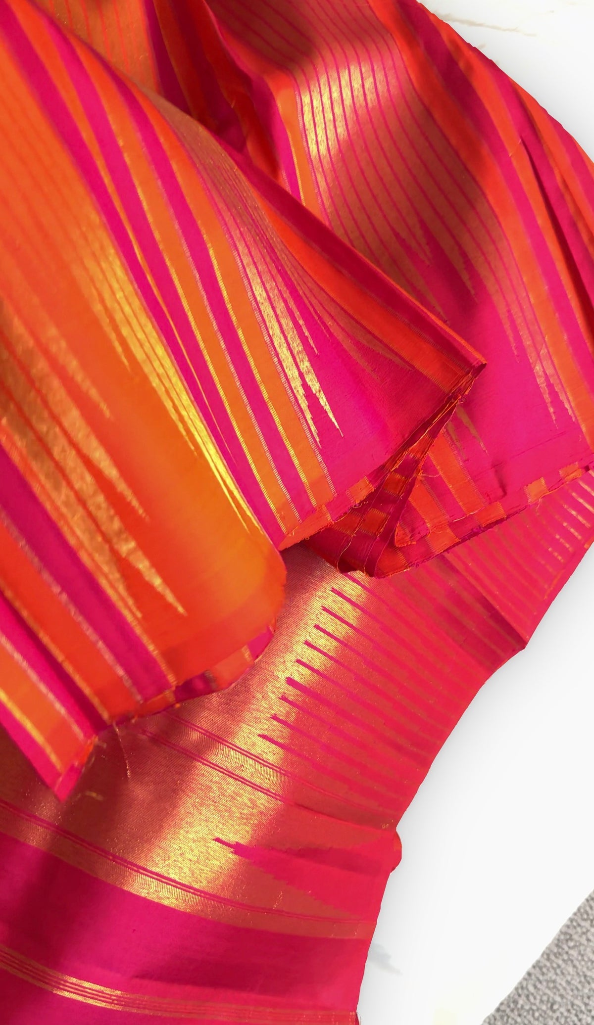 Pink Sunset Orange Kanchipuram saree with traditional Ettukol weaving.