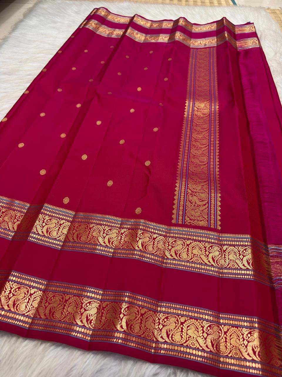 Fine geometric gold-zari lines framing the layered Rettapet ornament.