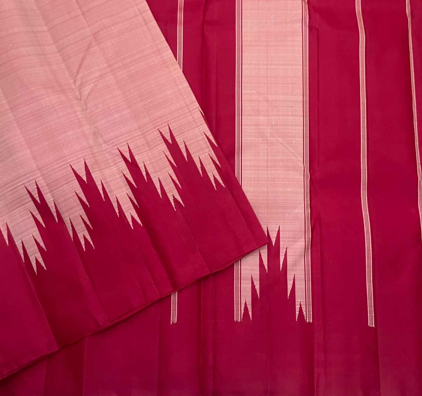 Folded scarlet red and pink Kanchipuram silk saree showing repeated reku motif along edge