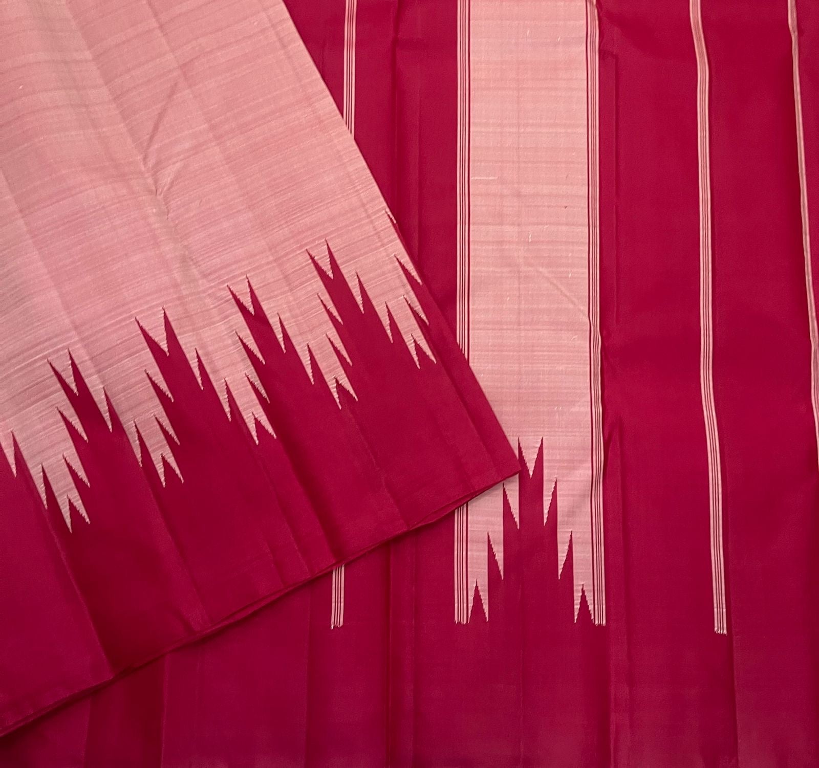 Folded scarlet red and pink Kanchipuram silk saree showing repeated reku motif along edge