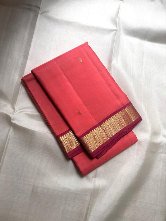 coral pink lightweight pure kanchipuram silk saree folded with narrow gold zari border